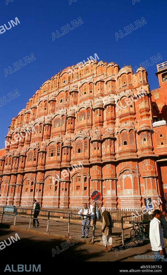 The Hawa Mahal was built in 1799 by Maharaja Sawai Pratap Singh, and designed by Lal Chand Ustad in the form of the crown of Krishna, the Hindu god. Jaipur is the capital and largest city of the Indian state of Rajasthan. It was founded on 18 November 1727 by Maharaja Sawai Jai Singh II, the ruler of Amber, after whom the city was named. The city today has a population of 3.1 million. Jaipur is known as the Pink City of India. The city is remarkable among pre-modern Indian cities for the width and regularity of its streets which are laid out into six sectors separated by broad streets 34 m (111 ft) wide. The urban quarters are further divided by networks of gridded streets. Five quarters wrap around the east, south, and west sides of a central palace quarter, with a sixth quarter immediately to the east. The Palace quarter encloses the sprawling Hawa Mahal palace complex, formal gardens, and a small lake. Nahargarh Fort, which was the residence of the King Sawai Jai Singh II, crowns the hill in the northwest corner of the old city. The observatory, Jantar Mantar, is a World Heritage Site.