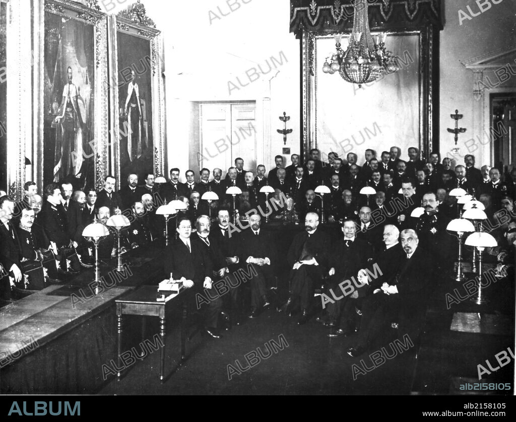 Petrograd, russsia 1917: first members of the provisional government in the state council chamber, alexander kerensky standing second from right (of faces not in shadow) .