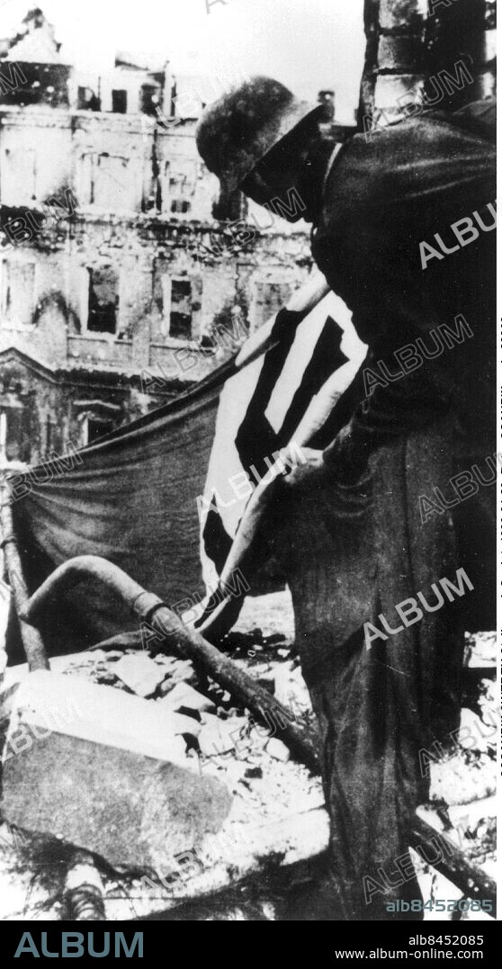 ©SCANPIX SWEDEN, 1943-01-31.. Andra världskriget.. Den 6:e armén kapitulerar i Stalingrad. Soldat med hakkorsflagga bland ruinerna.. Foto: Scanpix. Code: 20360.