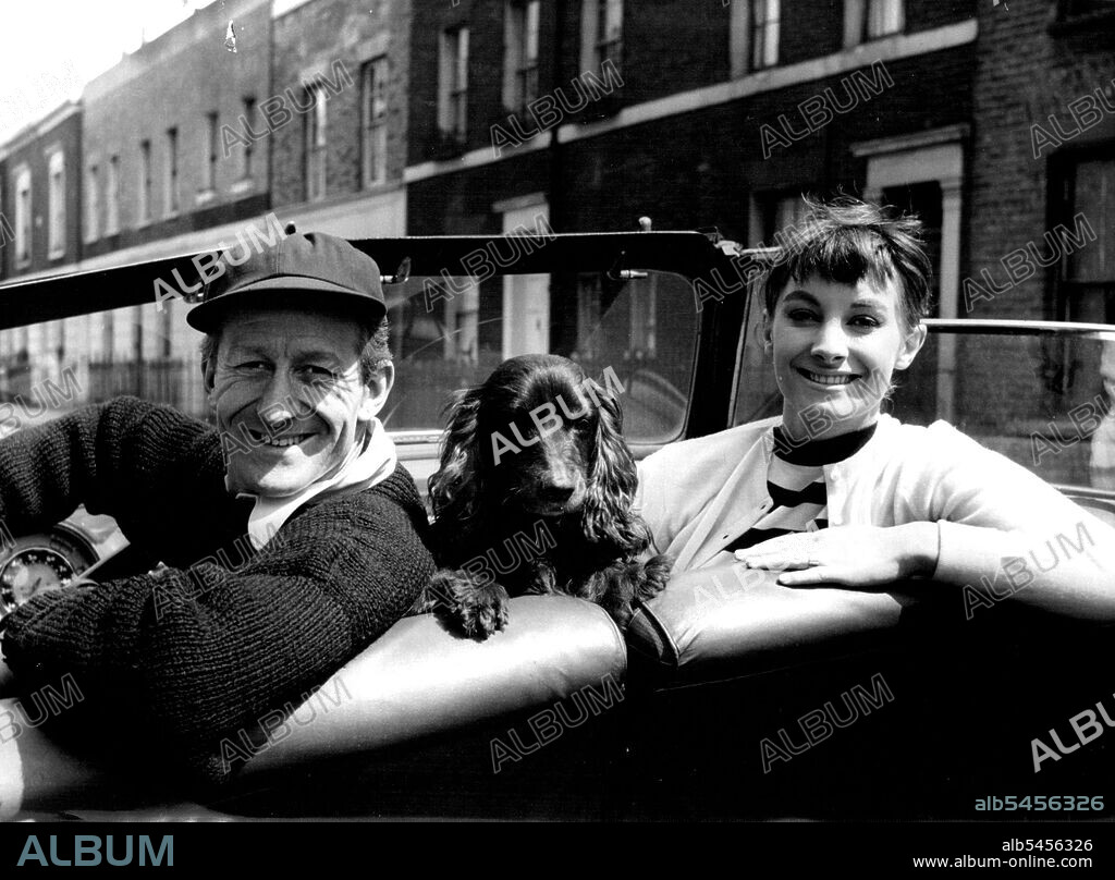 Jon Pertwee And His Wife, Jean Marsh -- Comedian Jon Pertwee photographed with his wife, actress Jean Marsh. Between them in the car is their pet spaniel, known as "The Pot". Jon is the brother of playwright Michael Pertwee; their father is Boland Pertwee, dramatist, novelist and short-story writer. November 01, 1955. (Photo by Tom Blau, Camera Press).