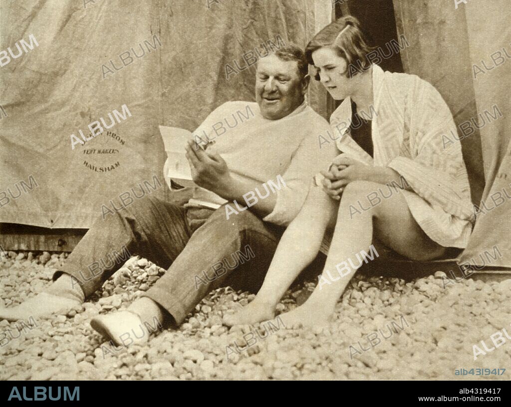 Gertrude Ederle receiving advice from her trainer Jabez Wolff, 1926, (1935). 'Miss Gertrude Ederle [1905-2003], the young American swimmer, was the first woman to swim the Channel [between England and France]. She also established a new record by swimming from France to England on August 6 [1926] in 14 hours 31 minutes, thus beating the previous record by about two hours.' From "The Silver Jubilee Book - The Story of 25 Eventful Years in Pictures". [Odhams Press Ltd., London, 1935].