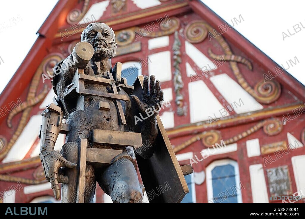 Statue of Goetz von Berlichingen by Gunther Stilling in front of the ornate half-timbered building of the Old Town Hall, Jagsthausen an der Jagst, Hohenlohe, Baden-Wuerttemberg, Germany, Europe, PublicGround, Europe.