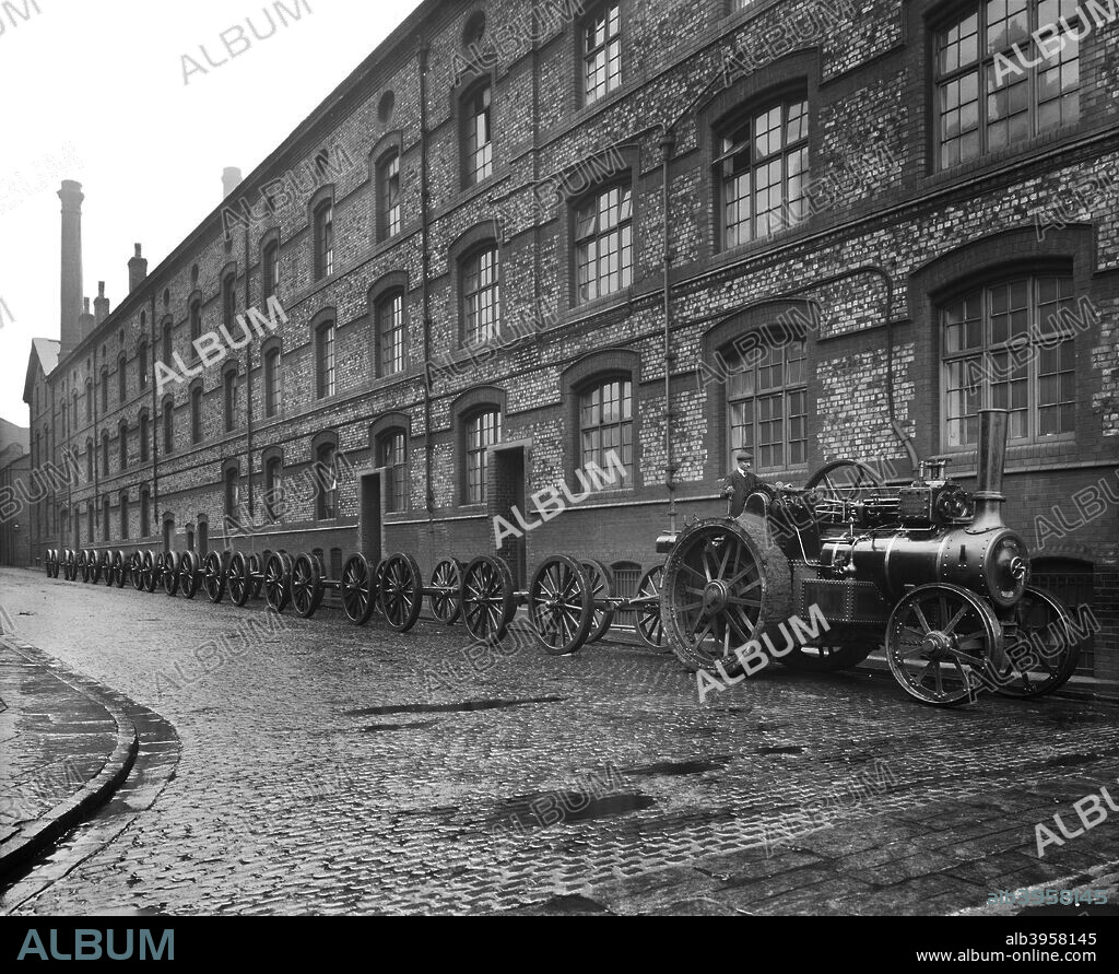 The gun carriage works, Cunard Engine Works, Derby Road, Kirkdale, Liverpool, January 1917. Exterior view with a traction engine pulling gun carriages along a cobbled road. Cunard had a number of sites around Merseyside, including warehousing and works in Rimrose Road, warehouses in Juniper Street and the engineering works in Derby Road.