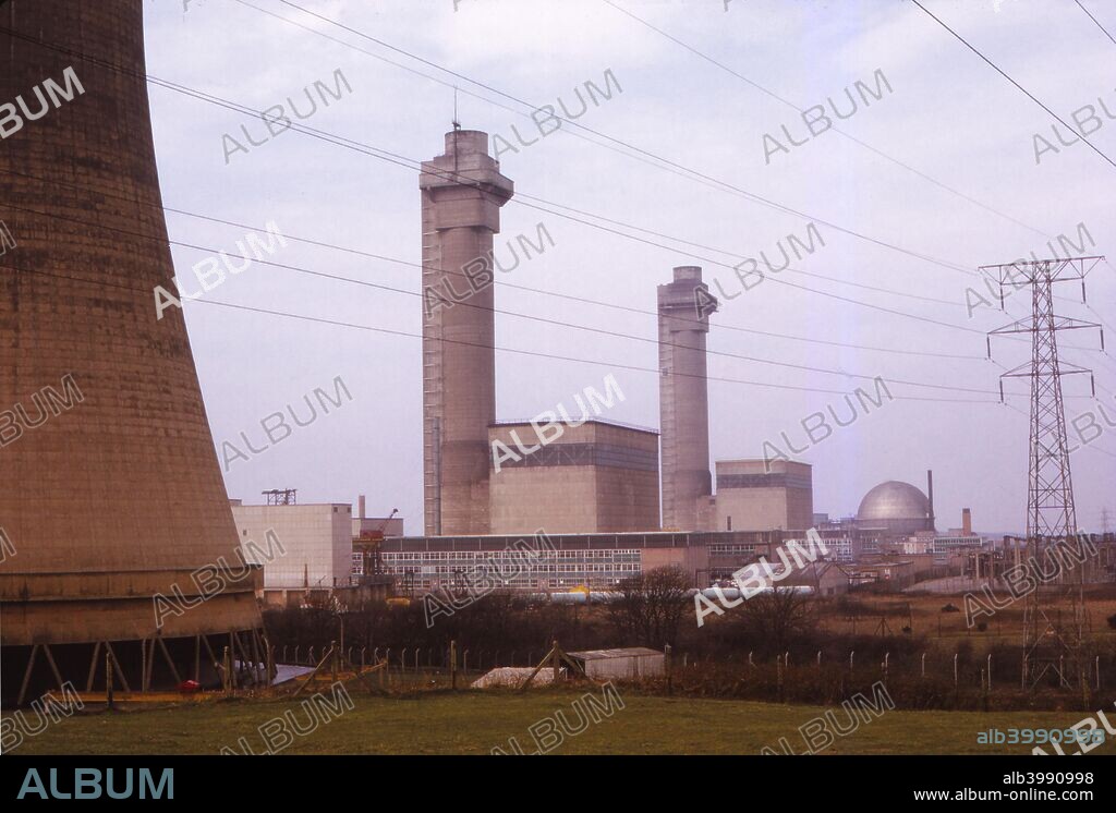 Calder Hall Nuclear Power Station, Cumberland, UK, 20th century. Cooling towers (left) and reactors (centre) with transmission lines at the world's first and oldest industrial-scale nuclear power station, in Sellafield, Cumbria.