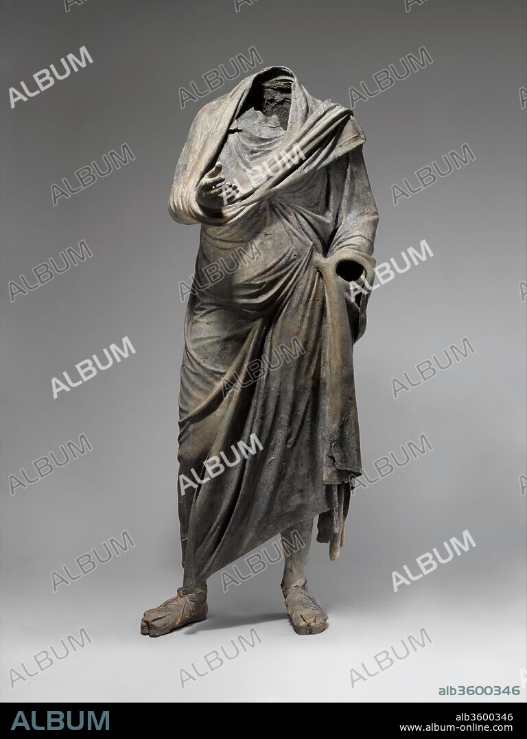 Bronze statue of a man. Culture: Greek. Dimensions: H. 73 in. (185.4 cm). Date: ca. mid-2nd-1st century B.C..
The figure stands in contrapposto. His right hand stretches out from the folds of his himation, with open palm and fingers curled upward in a gesture of oration. His left arm lays close to his body. The himation is kept in place in part by a tasselled weight, thrown over his left shoulder, which hangs at his calf. A rare detail, several horizontal bands decorate the fabric, and may have been painted or gilded. The indication of his musculature and anatomy continues underneath his garment.
Honorific statues like this one were typically portraits of prominent individuals awarded by the city-state or ruler in gratitude for significant benefactions. They were the highest honor that a city could offer. This impressive figure stands in contrapposto. His right hand stretches out from the folds of his himation (cloak), with open palm and fingers curled upward in a gesture of oration. His left arm lies close to his body. The himation is kept in place in part by the tasseled weight thrown over his left shoulder, which hangs at his calf, and the indication of his musculature and anatomy continues underneath his garment. The several horizontal bands that decorate the fabric,which may have been painted or gilded, comprise a rare detail.