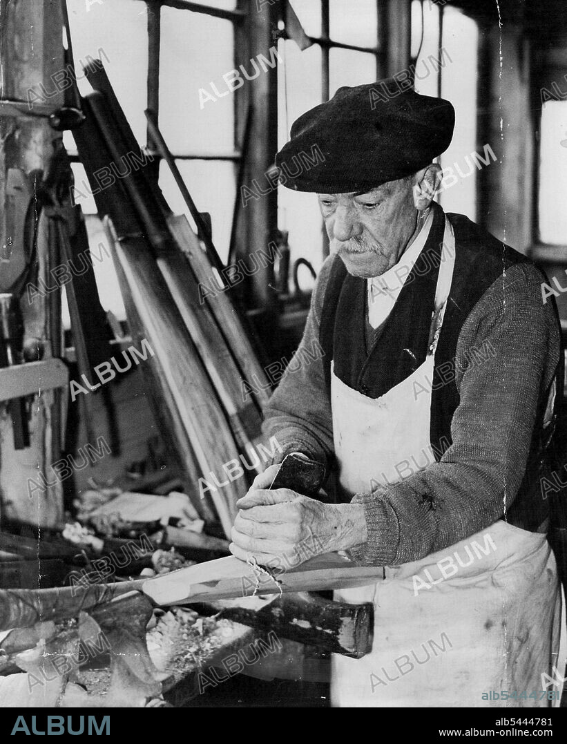 Famous Bat - Maker's Shed To Be Demolished Outside The Oval - ***** Killick at work in his shed at the back of his house in Clayton-street, shortly to be demolished. The old shed just outside the Oval a resort of famous cricketers for sixty years or more, is to be demolish shortly to make room for a block of new L.C.C. flats. The shed is owned by Albert Killick the last surviving member of a famous firm of batmakers. Who is collecting up his tools, preparing to move to new business premises. April 9, 1934. (Photo by The Associated Press).
