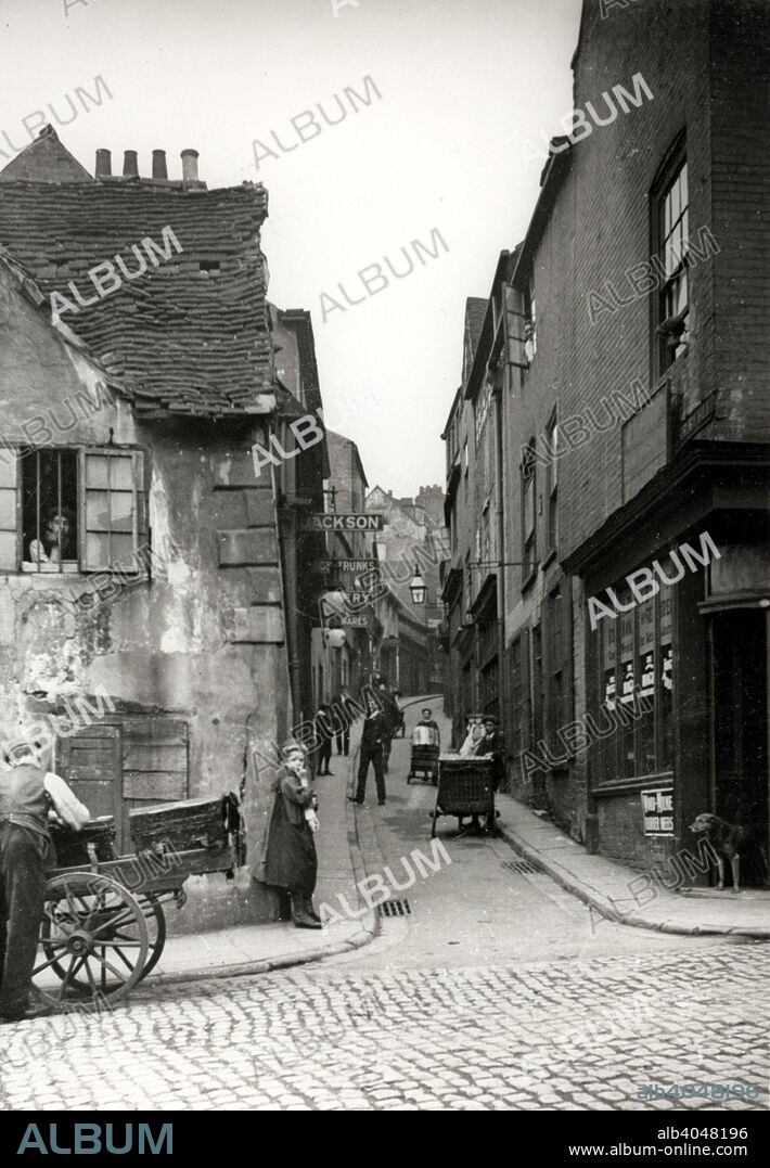 Drury Hill, Nottingham, Nottinghamshire, 1906. Jackson's on the left, Danby on the right. Taken from Middle Marsh. This narrow lane was only 4ft 10 inches wide at its narrowest point and signs had to be posted to alert traffic to this hazard. All of these buildings have now gone. The location is roughly where the escalators descend at the Bridlesmith gate - Middle Pavement entrance of Broadmarsh Shopping Centre.