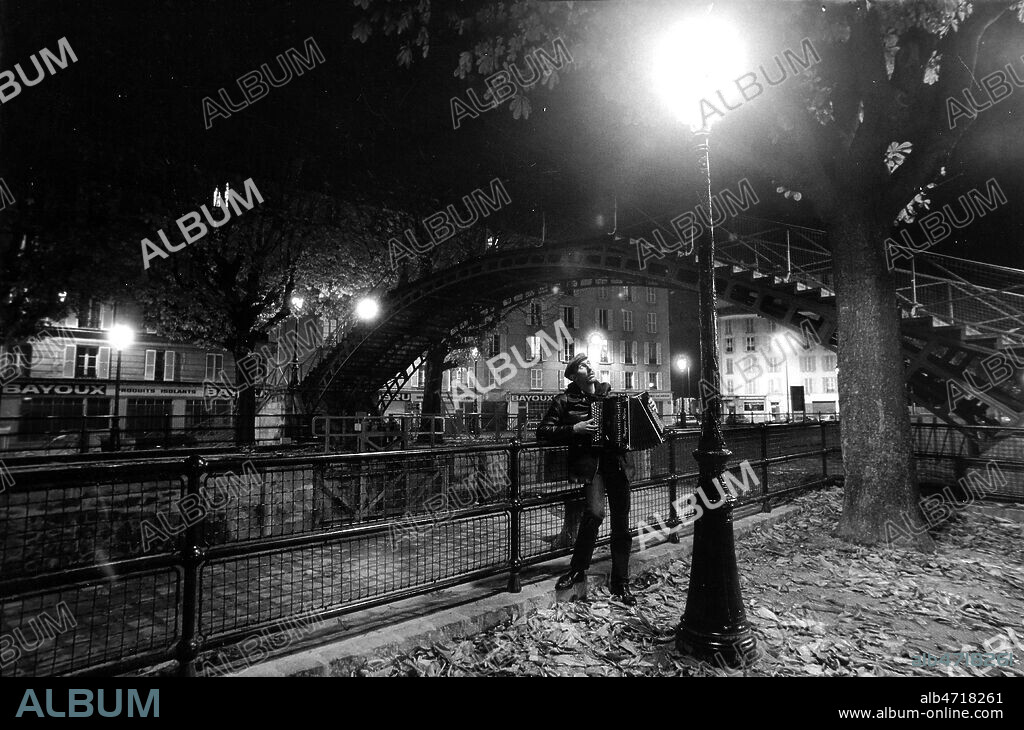 Chanteur des rues a Paris. Accordeoniste sous un reverbere, pres du canal de l'Ourq, Herve HAINE. Photo Francis CAMPIGLIA/Kharbine Tapabor.