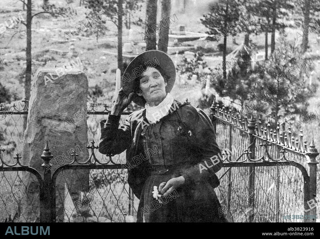 Calamity Jane, standing by the grave of Wild Bill Hickok, photogrpahed by J.A. Kumpf, 1903. Martha Jane Canary (May 1, 1852 - August 1, 1903), better known as Calamity Jane, was an American frontierswoman and professional scout. She received little to no formal education and was illiterate. She worked as a dishwasher, a cook, a waitress, a dance-hall girl, a nurse, and an ox team driver. In 1874, she found work as a scout at Fort Russell. In 1876, she settled in the area of Deadwood and became friendly with Wild Bill Hickok and Charlie Utter. After Hickok's death she continued living in the Deadwood and in late 1876 or 1878, she nursed the victims of a smallpox epidemic. In 1881, she bought a ranch in Montana, along the Yellowstone River, where she kept an inn. In 1893, she started to appear in Buffalo Bill's Wild West as a storyteller. She also participated in the 1901 Pan-American Exposition. She returned to the Black Hills in the early spring of 1903. It was reported that she had been drinking heavily on board the train and became very sick to her stomach. She died soon afterward from inflammation of the bowels and pneumonia. She was buried at Mount Moriah Cemetery, South Dakota, next to Wild Bill Hickok.