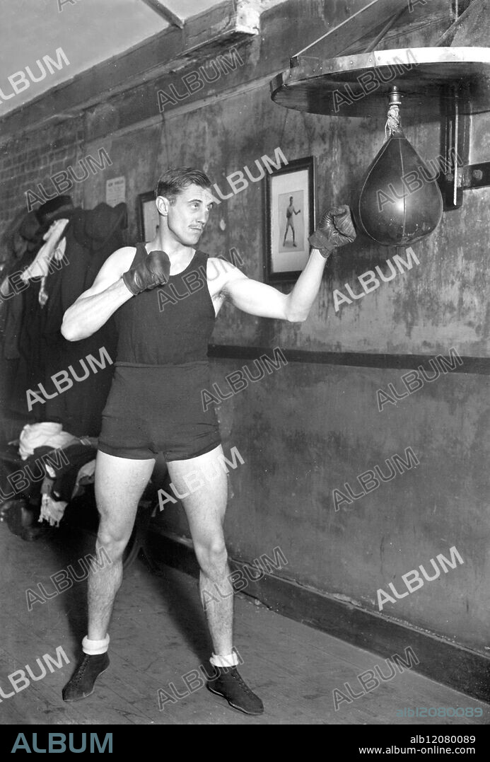 BOXING PEER IN TRAINING FOR FIGHT WITH POLICE-CONSTABLE. : Lord Knebworth, the 23 year old heir of the Earl of Lytton, who has already distinguished himself as a boxer of the welter-weight class, is in strict training for his four-round contest with Police Constable Bone of the Metropolitan Police at Ilford on April 2. He is training under Mr Alan Lambert with Alf Mancini, the professional boxer, as his sparring partner. Photo Shows: Lord Knebworth in fighting attitude at his training quarters. United Kingdom 1928.