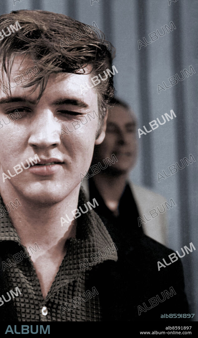 Vintage candid image of The King, Elvis Presley photographed early in his career in 1956 in Memphis Tennessee by Lloyd Dinkins.. Elvis Aaron Presley, also known simply as Elvis, was an American singer, musician, and actor. He is regarded as one of the most significant cultural icons of the 20th century and is often referred to as the "King of Rock and Roll" or simply "The King". His energized interpretations of songs and sexually provocative performance style, combined with a singularly potent mix of influences across color lines during a transformative era in race relations, led him to great success and initial controversy.
