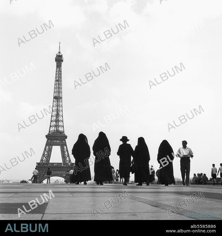 Paris, Tour Eiffel (1885-89, ingénieur G. Eiffel). Groupe de visiteurs à la Tour Eiffel. De la série : "Tour Eiffel". Photo, vers 1960 (?).