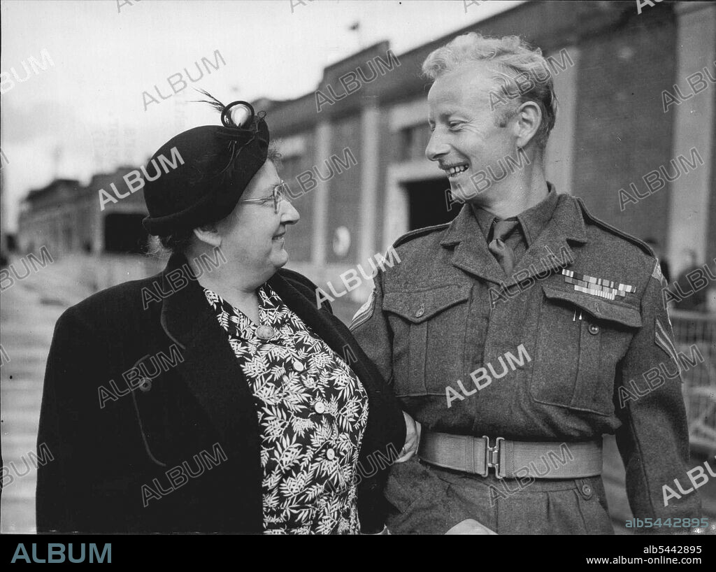 He Wouldn't Swallow Propaganda -- Corporal Alfred Edwin Holdham, M.M., of the 'glorious Gloucesters', who was beaten up in prison camp because he would not listen to Communist propaganda, is met by his mother, Mrs. Elsie Holdham of Wembley, London, when he lands with other ex-prisoners of war from the troopship Asturias at Southampton to-day (Wednesday). More than 500 British ex-prisoners from Korea came home on the trooper. September 16, 1953. (Photo by Reuterphoto).