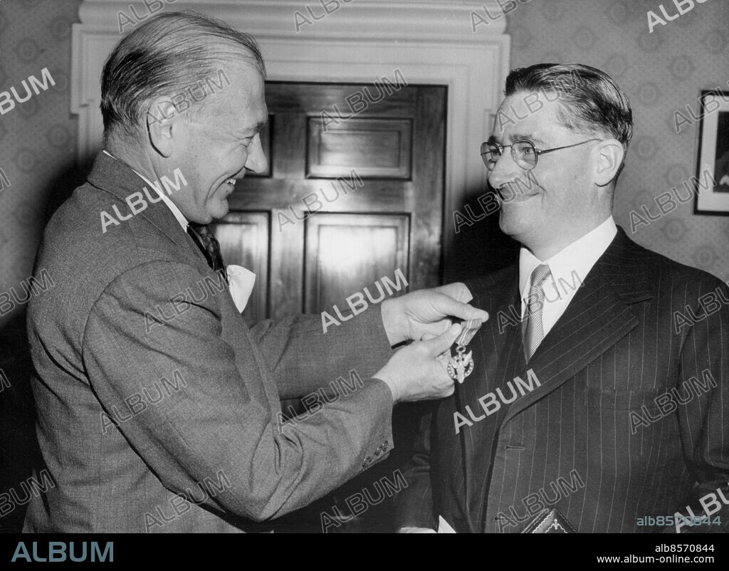Orig. bildtext... UNITED STATES MEDAL FOR MERIT GIVEN TO BRITISHERS BY U.S. AMBASSADOR IN LONDON TO-DAY -FOR OUTSTANDING SERVICES TO UNITED NATIONS 18.5.48 Three Britishers - Sir Alexander Fleming, of Penicillin fame, - Sir Howard Florey, also famous for his work on penicillin, - and Sir Edwin Herbert, who organised the first really competent and worldwide censorship in history during the World War II, - were presented with the United States Medal for Merit by the American Ambassador, Mr. Lewis W. Douglas, at the American Embassy, Grosvenor Square (London) to-day. The Ambassador made the awards on behalf of the President of the United States, Mr. Harry Truman. PHOTO SHOWS:- Sir Howard Florey, seen being presented with the United States Medal for Merit by the American Ambassador, Mr. Lewis Douglas, at the American Embassy, Grosvenor Square, (London) to-day. Sir Howard Florey was presented with the Medal for Merit for Outstanding Services to the United Nations from 1939 to 1945. Sir Howard distinguished himself during this period through important contributions and fundamental researches in the development of penicillin, and made possible the large scale production of penicillin for the incalculable benefit of the sick and wounded. Anm. L Williams Douglas, 1894-1974, amerikansk politiker, diplomat, affärsman och akademiker, ambassadör i Storbritannien 1947-1950. H Florey, 1898-1968, brittisk patolog, fick nobelpriset i medicin 1945, tillsammans med Alexander Fleming och Ernst Boris Chain, för upptäckten av penicillinet och dess medicinska verkningar. Anm. Leenden Randigt Ränder Kritstrecksrandigt Utmärkelser Nobelpristagare Profiler Överlämna CD579 persons: LEWIS DOUGLAS;HOWARD FLOREY sites: USA*;STORBRITANNIEN;LONDON.