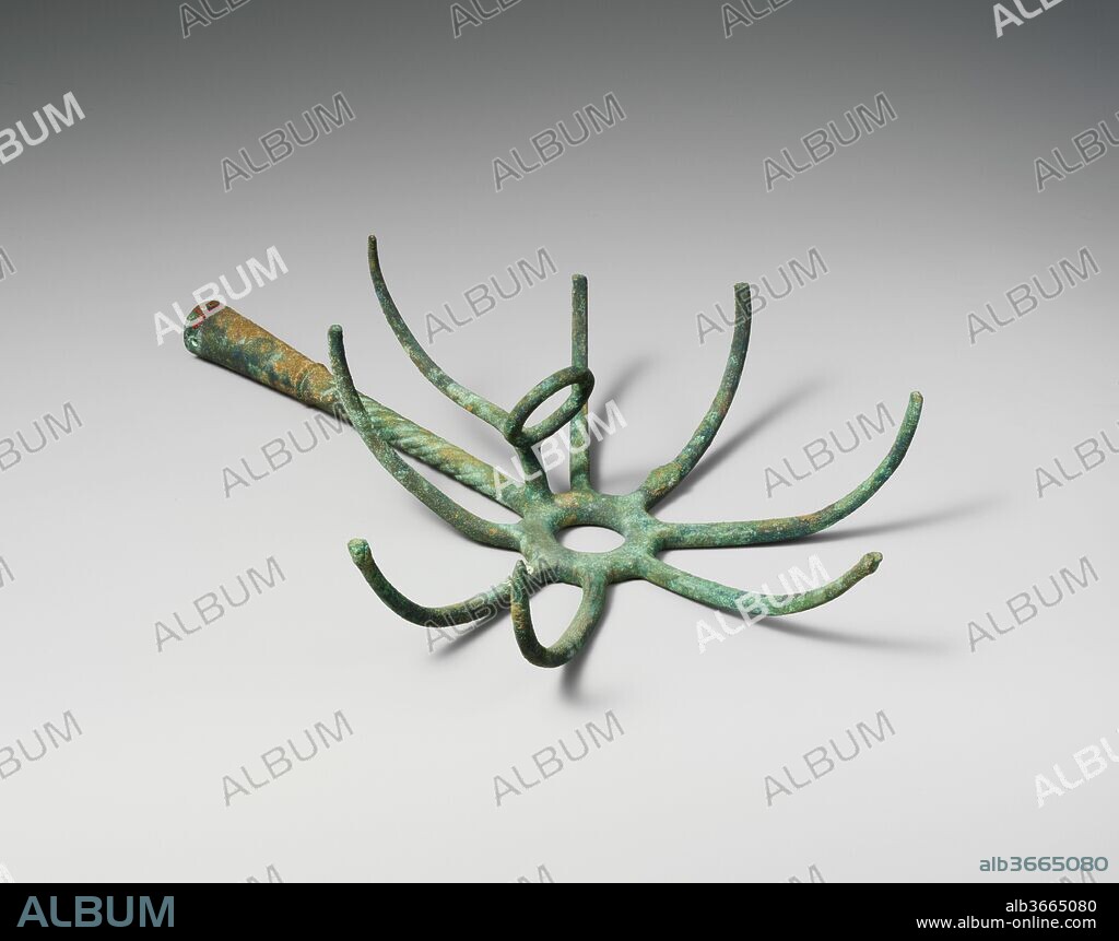 Bronze torch-holder. Culture: Etruscan. Dimensions: Other: 10 13/16 in. (27.5 cm). Date: late 5th century B.C..
Numerous examples of such objects have been found in tombs of Etruscan warriors, and scholars have debated their function. Most thought that they were  hooks for retrieving meat from cooking vessels. But the engraved mirror, 96.18.15, displayed in the mirror case shows a figure using the object as a torch-holder. The utensils may have been supplied to soldiers for use on night missions and later became part of their funerary equipment.