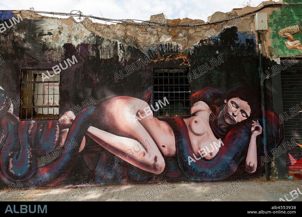Pintura de mujer recostada desnuda enredada con serpiente, graffiti mural, calle Espronceda, barrio Poblenou; Distrito San Martin, Barcelona en 2016.