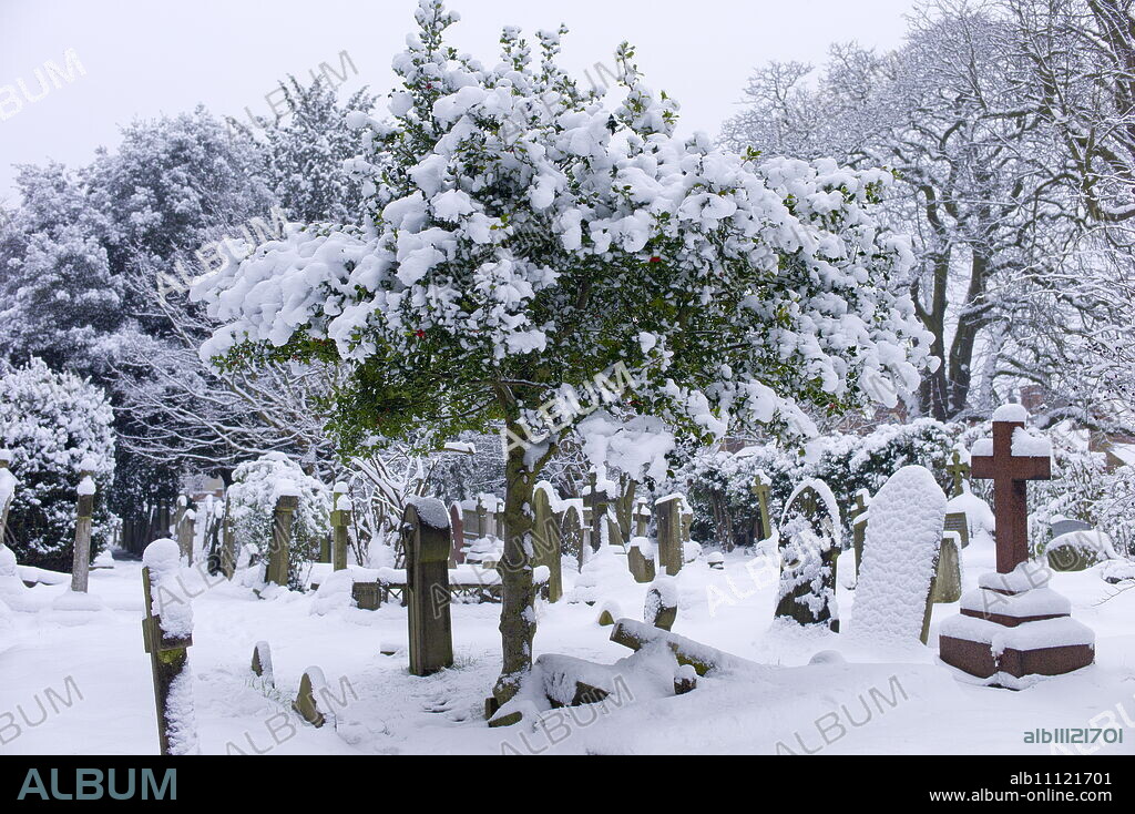 Snow-covered gravestones in Hampstead Parish Graveyard in Church Row and Holly Place in Hampstead, North London, UK.