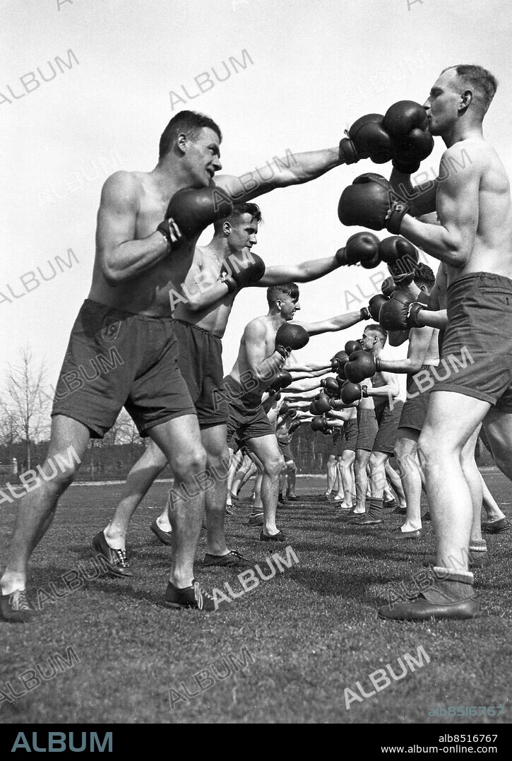 TYSKLAND WÜNSDORF omkring 1930. Orig. bildtext... REICHSWEHRBOXER TRAINIEREN. In der Heeressortschule in Wünsdorf, in der die sportlichen Führer unserer Reichswehr ihre Ausbildung erhalten, herrscht tagtäglich grosser Trainingsbetrieb. Neben den allgemein gepflegten leichtathletischen Übungen werden in Wünsdorf auch Spezialsportarten wie Boxen und Baumstammwerfen ausgeübt. Unsere Aufnahme zeigt Kursusteilnehmer der Wünsdorfger Heeressportschule beim schulgemässen Boxen. Ein "linker Gerader" wird geübt. Foto: Scherls Bilderdienst / AB Text & Bilder / SVT / Kod: 5600 Mapp: Boxning (Boxare i träning) I:49b Idrottsskola för den tyska militären sites: WÜNSDORF;TYSKLAND PhotoDate:193?-??-??.