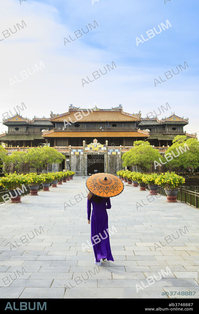 Woman in a traditional Ao Dai dress with a paper parasol in the Forbidden Purple City of Hue, UNESCO World Heritage Site, Thua Thien Hue, Vietnam, Indochina, Southeast Asia, Asia.