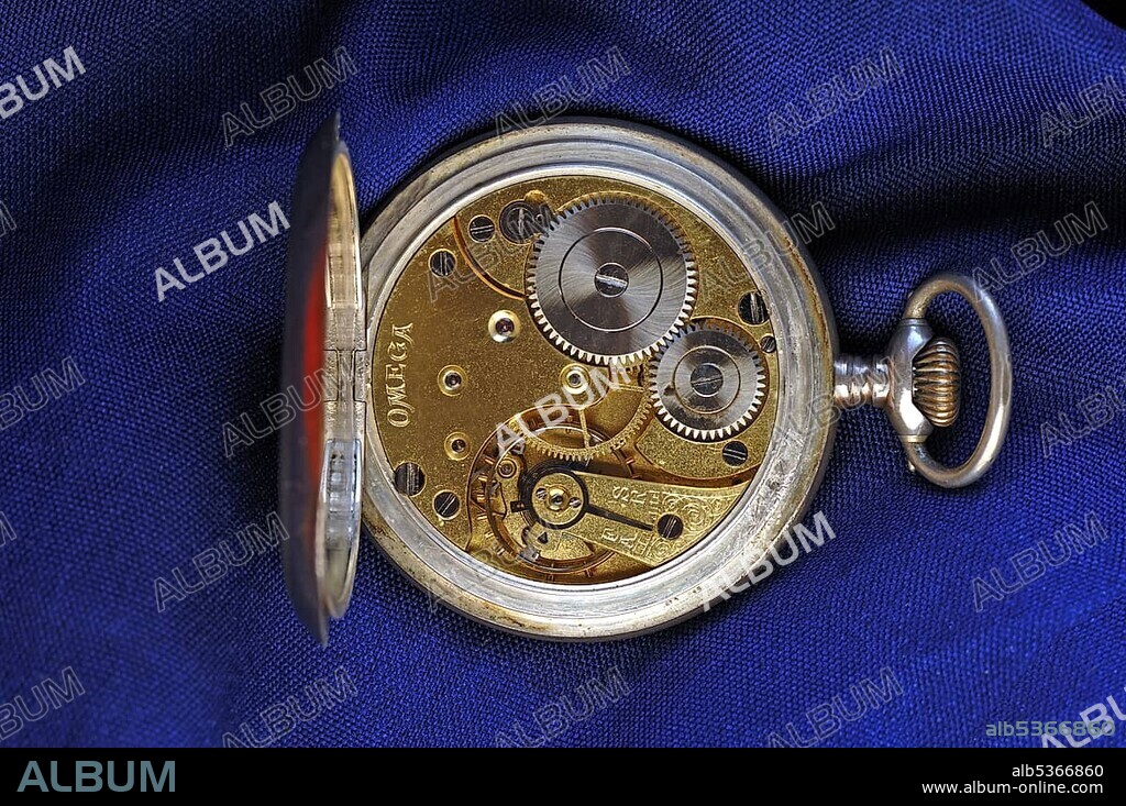 Clockwork of the Omega Grand Prix Paris 1900 pocket watch on a blue fabric.