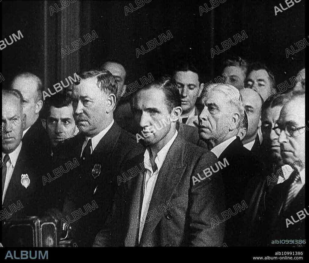 Bruno Richard Hauptmann Entering a Court Room for a Bail Hearing in Connection With the Lindbergh's Case, 1930s. Hauptmann: 'A man whose neat records of his savings and expenses showed, that while in America he had spent $49,950 more than he had earned...Hauptmann appealed to be released on bail, but when he was brought before the judge, such was the nature of his crime, that there was little hope...The state was in no mood to be lenient, so into jail he went'. From "Time To Remember -  The Tough Guys", 1930s  (Reel 3); documentary film, mainly about life in depression- and gangster-hit America.