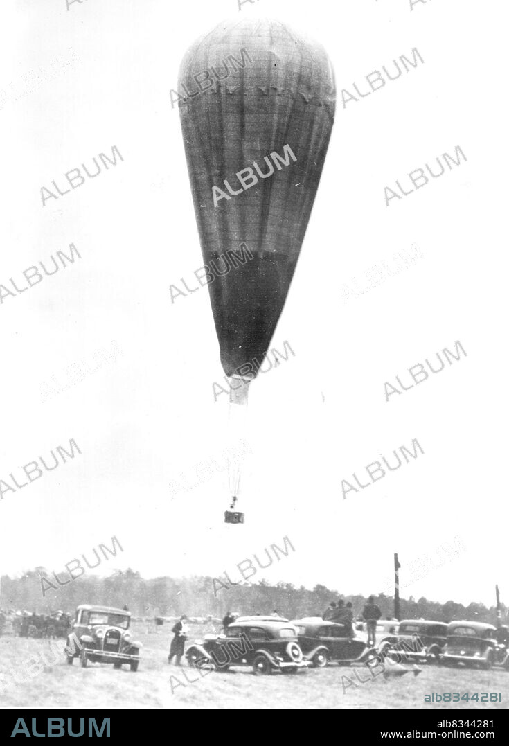 Aloft On Stratosphere Flight -- The wind had died to absolute calm as the balloon of Prof. and Mrs. Jean Piccard was cast off on its flight into the upper air Oct 23. The picture shows the big bag, which had a capacity of 600,000 cubic feet of hydrogen gas, as it left the ground at the ford Airport, near Detroit. The balloonists landed several hours later near Cadiz Ohio, unhurt. October 23, 1934. (Photo by Associated Press Photo).