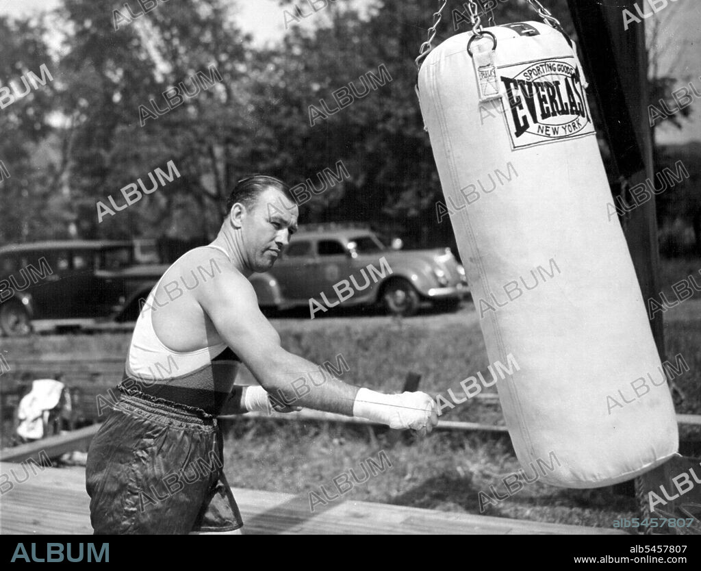 Sharkey Punches The Bag
Jack Sharkey shown punching the heavy sand bag at his training camp here today as he began his workouts preparatory to his heavyweight fight with Joe Louis. February 17, 1953. (Photo by Associated Press Photo).
