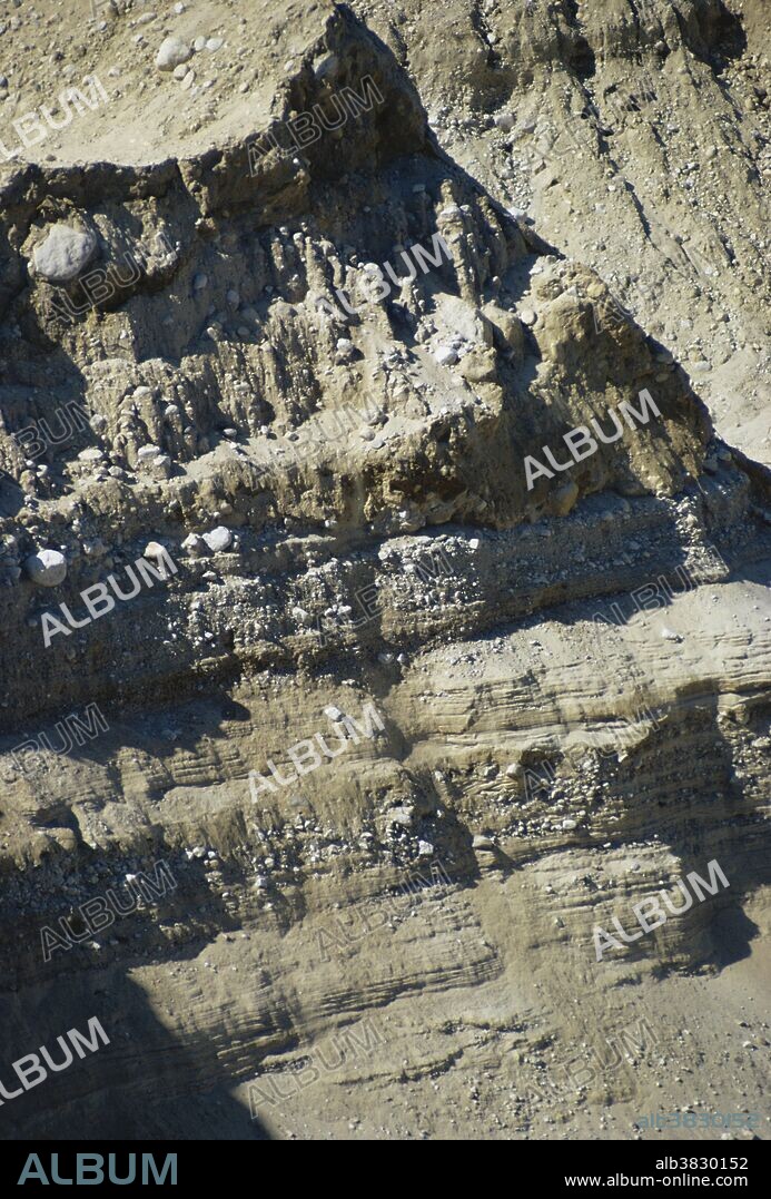 Unlayered glacial till covers outwash deposits of clay and gravel sorted by the meltwater streams of a fluctuating ice sheet.