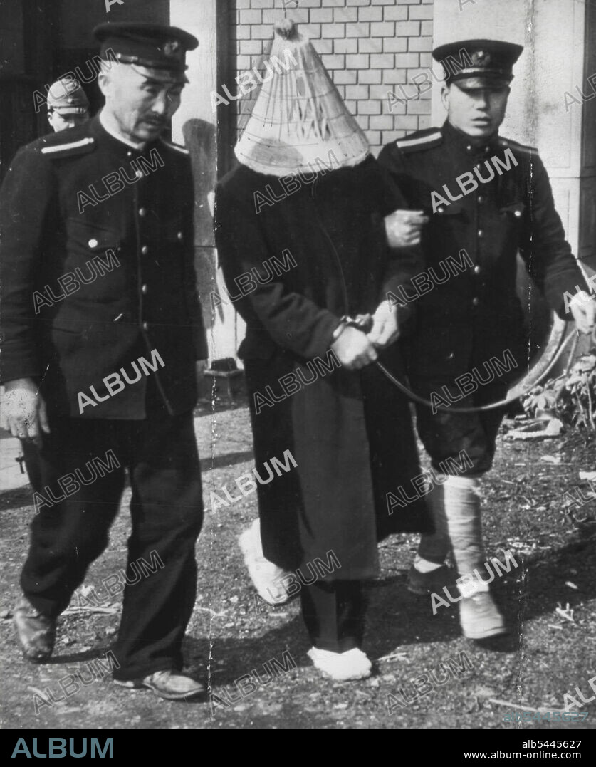 Japanese "Bluebeard" Goes To Court - Flanked by two policemen, one of whom holds the traditional rope attached to the prisoner's handcuffed wrists, Yoshio Kodaira, 43, is taken to court in Tokyo to face charges that he was responsible for the deaths of 10 women. Under Japanese law the straw hat he wears is allowed to hide his shame. March 14, 1947. (Photo by AP Wirephoto).