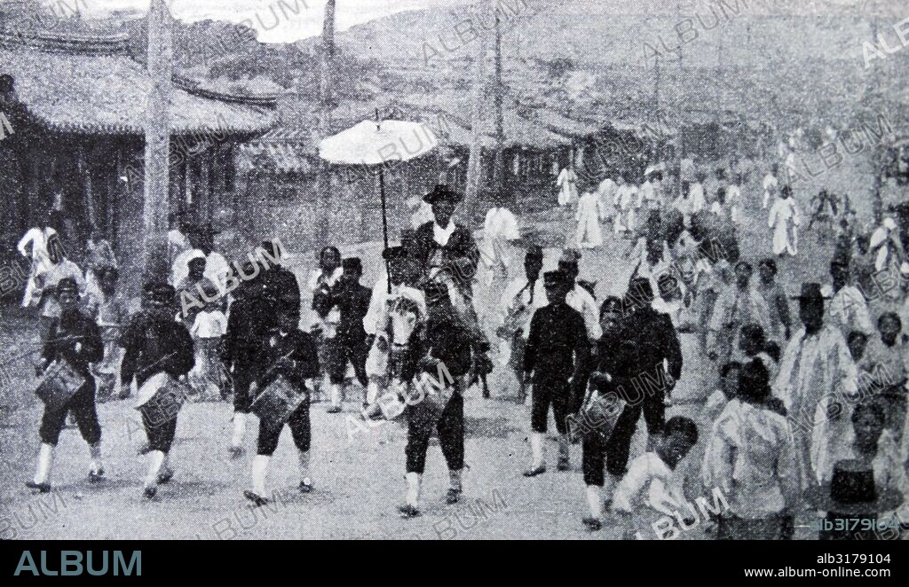 Emperor's grand master of the Horses rides with escort through the Korean city of Seoul, 1900.