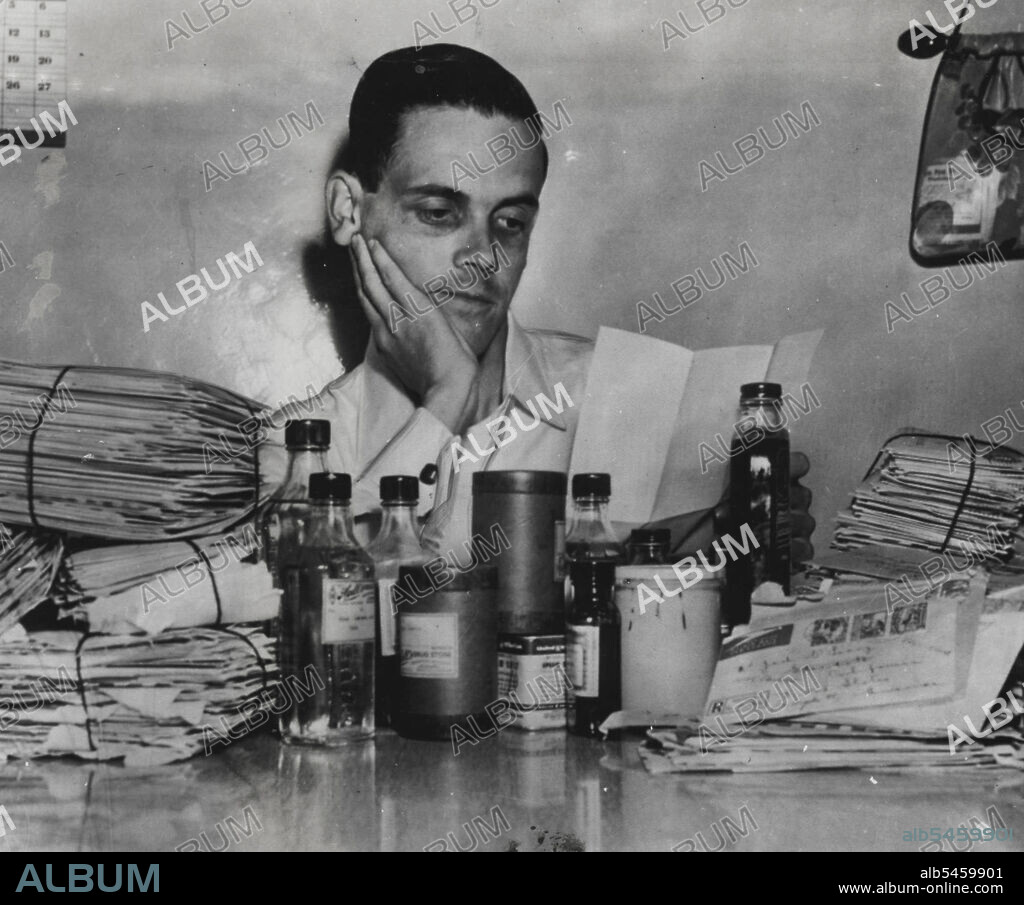 Hiccup Victim Returns Home--Still Hiccuping -- Still suffering from hiccups which have plagued him for 23 months, Jack O'Leary is back home today after five months in Arizona. He's reading some of the mail sent from all parts of the world with suggestions for cures. On the table are some nostrums sent by well-wishers, none of which has worked. O'Leary got some relief in Arizona's dry climate but the spasms have resumed since his return to California. May 16, 1950. (Photo by AP Wirephoto).