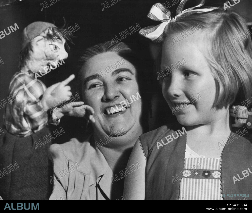 Puppet Simple Simon, manipulated by Mrs. J. Ferguson, of Randwick, at Legacy's "All Nations' Fair", had a delighted watcher - Nanette Neilson, 8, of Russell Lea. November 20, 1953.
