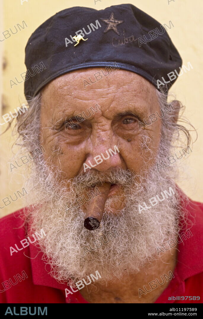 An old man with cap and white beard smoking a cigar, Havana, Cuba, West Indies, Central America.