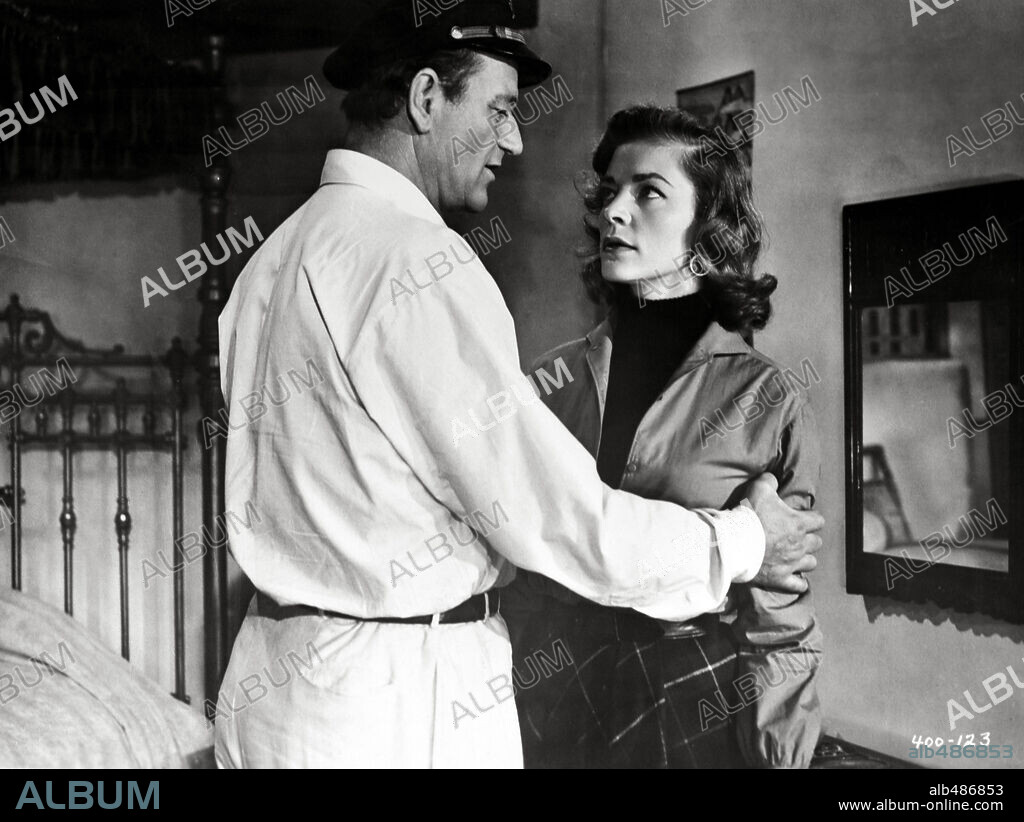 JOHN WAYNE y LAUREN BACALL en CALLEJÓN SANGRIENTO, 1955 (BLOOD ALLEY), dirigida por WILLIAM A. WELLMAN. Copyright WARNER BROTHERS.
