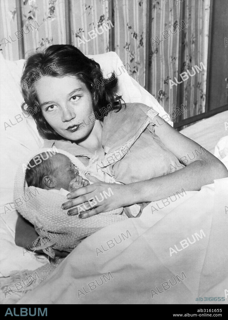 Ft. Worth, Texas: November 23, 1934 Fourteen yeear old Ellen Mullins nursing her new baby girl. Her husband is also fourteen and they nmarried last spring and quit school. 'And it's grand' says Ellen's mother, who became a grandmother at 33.