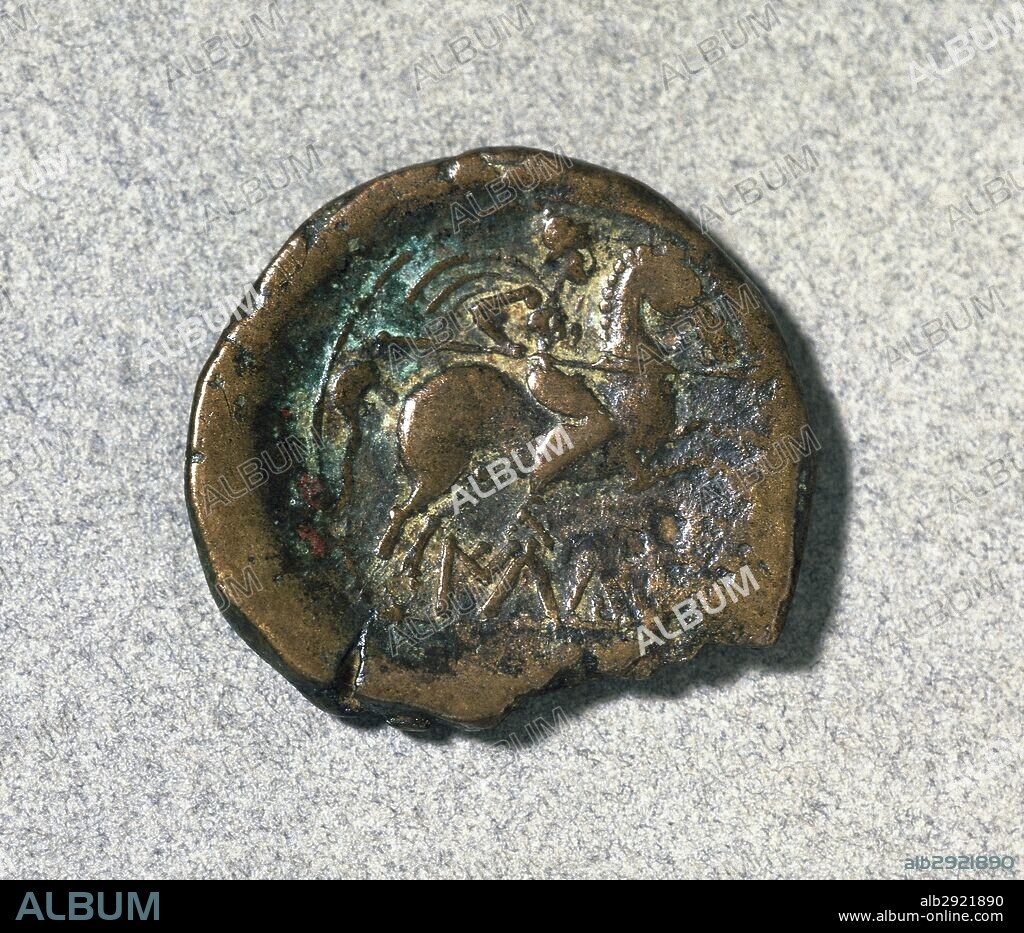 MONEDA ROMANA. Reverso de un AS íbero-romano que presenta un JINETE CON LANZA y CLAMIDE con LEYENDA en la parte inferior. Fechado en el siglo I a. C. Bronce. CECA DE ILDURO (MATARO, provincia de Barcelona). Museo de Historia de Sabadell. Provincia de Barcelona. Cataluña.
