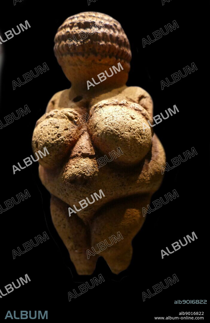 Photograph of the Venus of Willendorf, an 11.1-centimetre-high (4.4 in) Venus figurine ; made between about 28,000 and 25,000 BCE. It was found in 1908 by a workman named Johann Veran during excavations conducted by archaeologists Josef Szombathy, Hugo Obermaier and Josef Bayer at a Palaeolithic site near Willendorf, a village in Lower Austria near the town of Krems. carved from an oolitic limestone that is not local to the area, and tinted with red ochre.