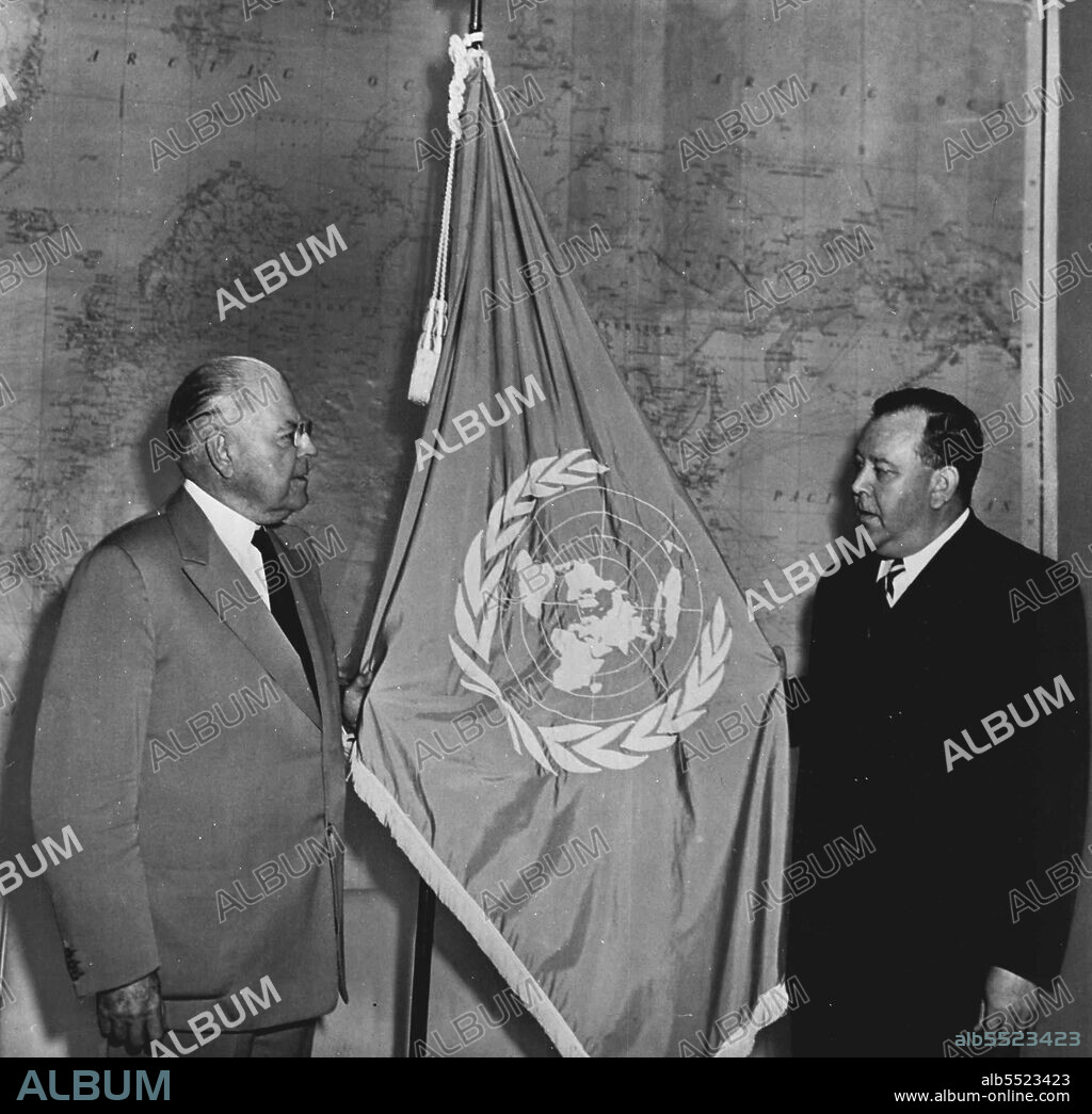 Trygve Lie (right), Secretary-General of the United Nations, presents the blue and white flag of the United Nations to Ambassador Warren Austin, United States representative to the United Nations. Until peace is re-established in Korea, this flag will be flown at the headquarters of General Douglas MacArthur; United States Army, Commanding General for the unified United Nations military forces assisting the Republic of Korea in defense against the North Korean Communist invasion. July 08, 1950. (Photo by United States Information Service).