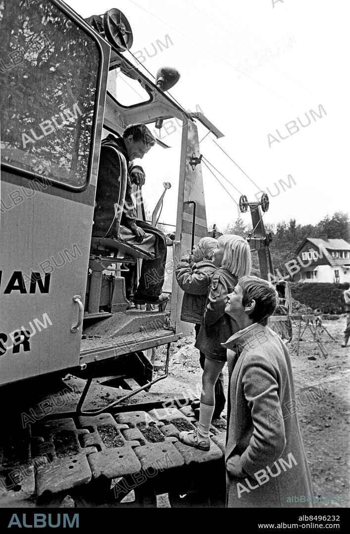 1969-09.. SMÅBARNSKVARTEN - VÅRA HJULBENTA VÄNNER. Radioprogram där Annika Kihlbom och några barn läser sagor och pratar om bilar.. Sänt första gången 1969-09-22.. Här aes Malin, 6 år, Staffan, 5 år, och Annika tala med en man som kör en grävskopa.. Foto: Bo-Aje Mellin / RiR / SVT / Kod: 5600. RiR 19565 sv/v . Barnprogram Grävskopor.