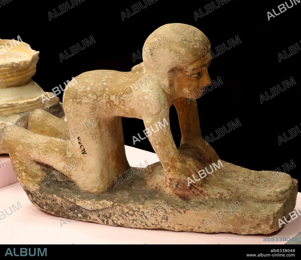 Ancient Egyptian model of a peasant grinding corn to make bread. From a tomb, at Giza, Egypt. circa 2686 -2125 BC. New Kingdom.