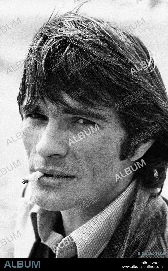 Luc Merenda smoking a cigarette on the set of the film Man without Memory. French actor and fashion model Luc Merenda smoking a cigarette during a break in the shooting of the film Man without Memory. Rapallo, 1974.