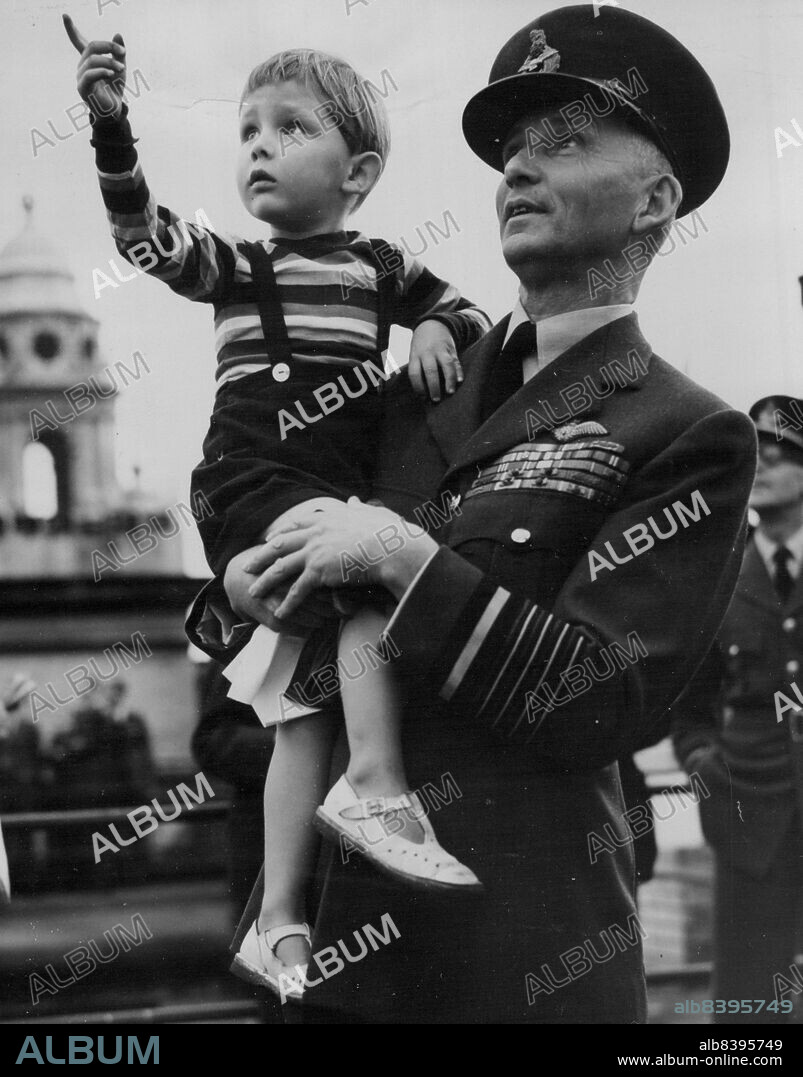 "Look Daddy" -- "Look daddy!", says three-year-old Richard, as his father, Marshal of the Royal Air Force Lord Tedder, holds him up to see the planes roaring over the roof of the Air Ministry here, during London's commemoration of the "Battle of Britain".Millions of Londoners watched, and remembered, as hundreds of planes, led by a lone Royal Air Force Hurricane fighter, symbolic of "The Few", flew in formation across London's skies. Planes of the Navy, the United States Air Force, as well as fighters and bombers of the R.A.F., took part in the Fly-past. September 15, 1949.