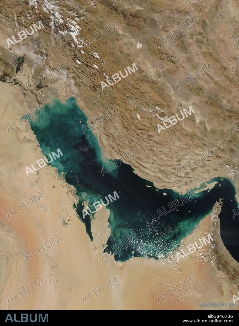 Persian Gulf captured by the MODIS on NASA's Aqua satellite on November 28, 2007. Near the shore, the color is almost certainly sediment washing into the gulf, turning the water tan and then green and finally blue as it disperses. The gulf is deeper on the east near the Iranian shore, where the water is clear and black. Much of the dirt clouding the water in this image is coming from the Shatt al Arab River, which enters the Gulf in the north along the Iran-Iraq border. On the right edge of the image is the narrow Strait of Hormuz, which connects the Persian Gulf to the Arabian Sea, part of the northern Indian Ocean. The Persian Gulf is flanked by the Arabian Peninsula with its vast tan, pink and white sand deserts on the southwest and the dry mountains of southwest Asia on the northeast. The wetlands and rivers of Mesopotamia border the gulf on the north. Snow dusts the mountains in the north. The region is rich in oil, and the red dots that typically mark fire locations in MODIS imagery may actually be gas flares in the oil fields, particularly along the northern shore of the gulf in Iran and Iraq.