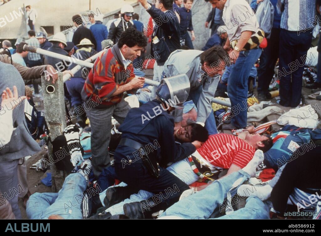 ©SCANPIX SWEDEN, 1985.. Fotbollsbråk på Heyselstadion i Bryssel.. Under europacupfinalen mellan Liverpool och Juventus på Heyselstadion i Bryssel omkommer 38 människor i våldsamma kravaller. Bilden visar dödade/skadade på en läktare efter tumulten. En kravallpolis undersöker kropparna.. Foto: Scanpix. Code: 20360.