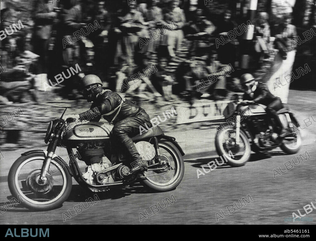 Motor Cycling "Duke" Wins Isle Of Man Race -- Geoffrey Duke riding a Norton (No.1) catching up on T. McEwen (also on a Norton) (No. 85) around the sharp corner at Governor's bridge during the race.Geoffrey Duke - "The Duke" of motor cycle racing - won the Senior International Tourist Trophy Race in the Isle of Man yesterday and smashed all his own records - by mistakes. On his second circuit of the course he misread a signal and thought he was lying third. He "burned up" the last 13 miles of the 38-mile course, touching 130 miles perhour and raised his lap record form 93.53 miles per hour to 95.22. June 9, 1951. (Photo by Paul Popper).