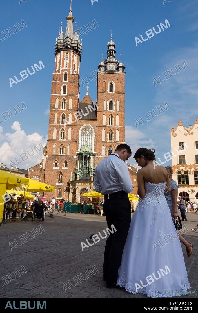 pareja de recien casados en Rynek GÅ‚ówny , plaza del mercado,basílica de Santa María -iglesia de la Asunción de la Santísima Virgen María-, estilo gotico, Cracovia , voivodato de Pequeña Polonia,Polonia,  eastern europe.