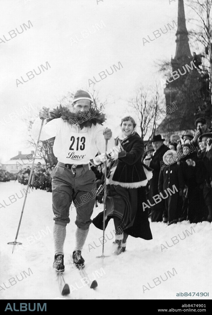 MORA 1955-03-06.. Sixten Jernberg, skidåkare från Lima, åker i mål som segrare i det 32:a Vasaloppet.. Foto: Alf Lidman / AB Text & Bilder / SVT / Kod: 5600. Mapp: Jernberg, Sixten A. Skidåkning Längdskidåkning Vinnare Segrare Vintersport Åskådare Nummerlappar Kransar Kranskullor.