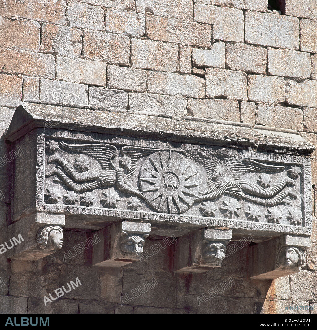 ARTE PALEOCRISTIANO. ESPAÑA. Iglesia de Sant Feliu. Al exterior del muro sur se adosa un sarcófago de piedra calcárea que en su frente representa dos ángeles que sostienen un sol, en el centro del cual se encuentra el cordero místico con la cruz. Girona. Cataluña.