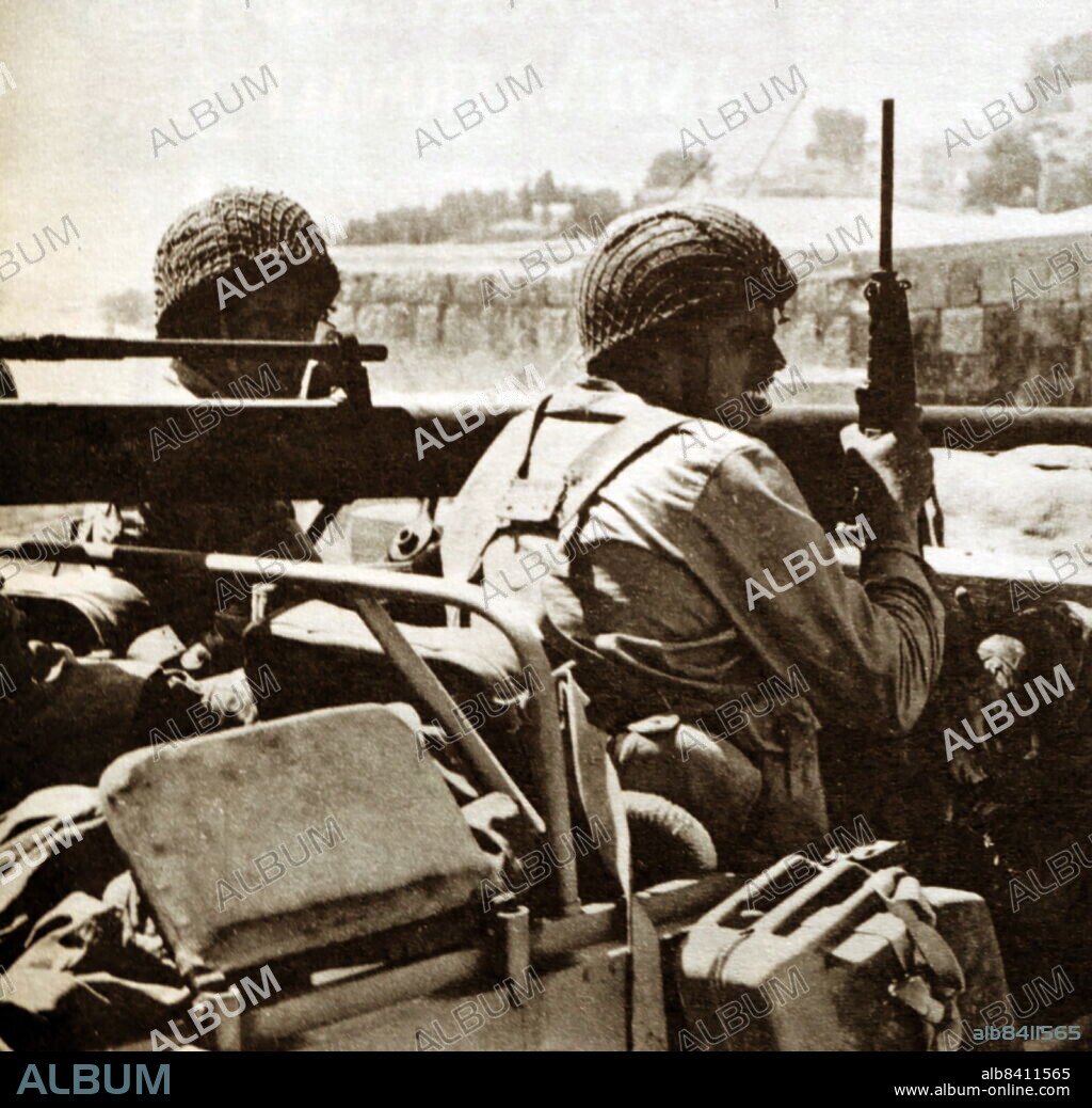 Patrol jeep carrying a recoilless rifle moves into a town during the 1948 (or First) Arab-Israeli War, the second and final stage of the 1947-1949 Palestine War. It formally began following the end of the British Mandate for Palestine at midnight on 14 May 1948; the Israeli Declaration of Independence had been issued earlier that day, and a military coalition of Arab states entered the territory of British Palestine in the morning of 15 May.
