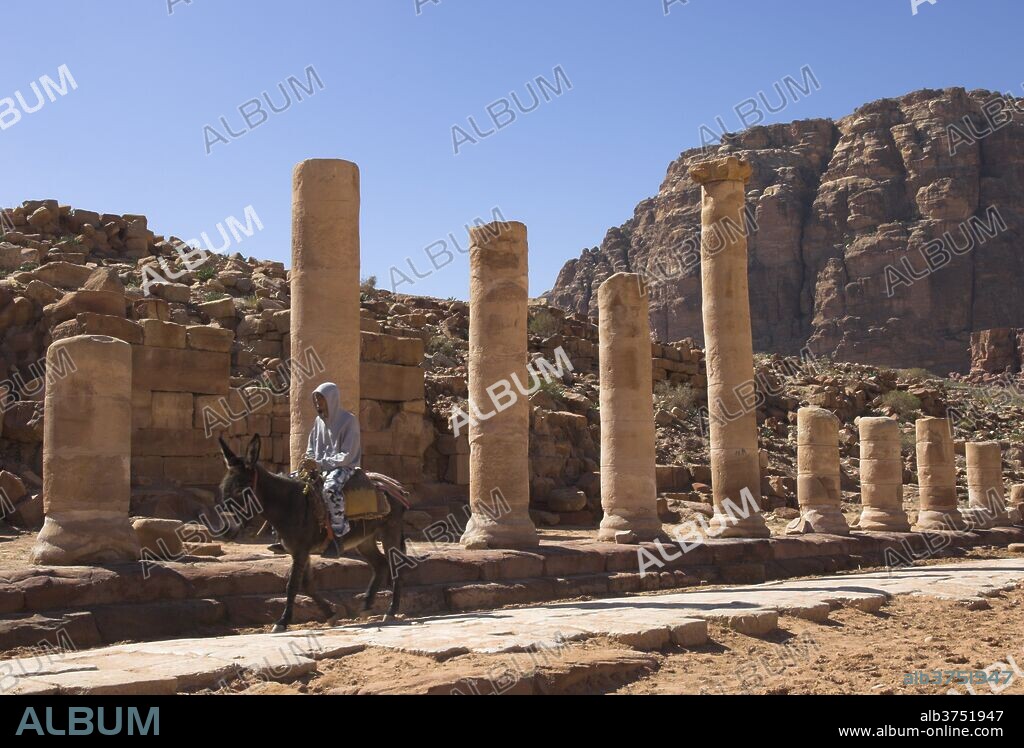 Bedouin on a donkey on the colonnaded street, Cardo Maximus, Petra, UNESCO World Heritage Site, Jordan, Middle East.